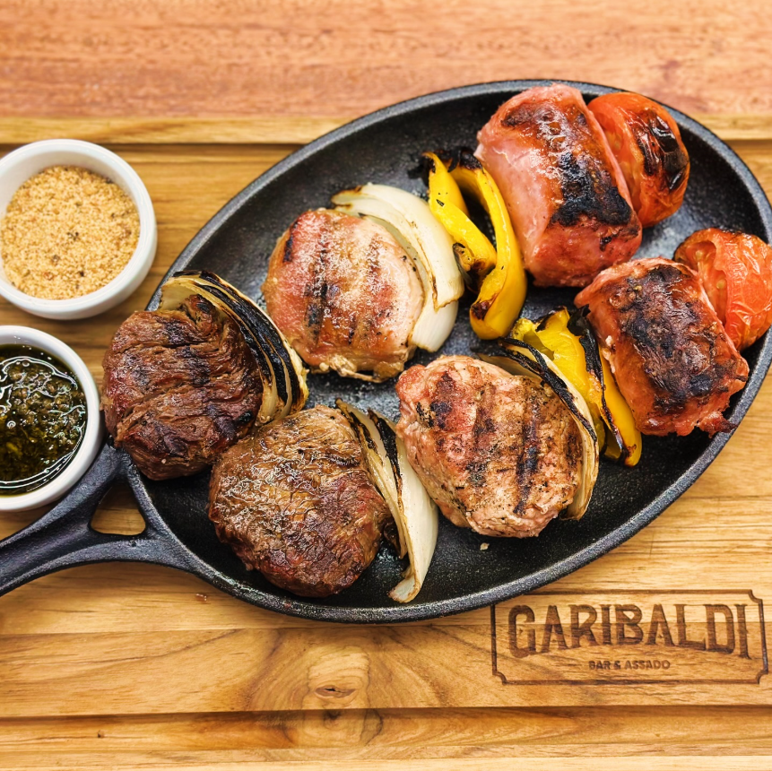 Cortes de picanha, frango com bacon e linguiça na chapa de ferro com legumes grelhados